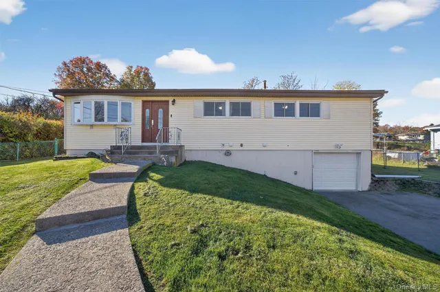 a front view of a house with a yard and potted plants