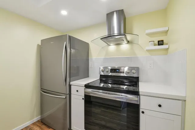 a metallic refrigerator freezer sitting inside of a kitchen