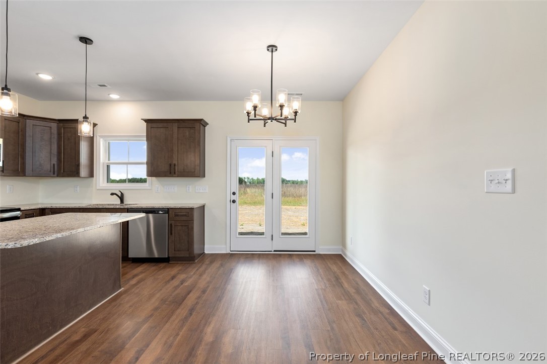 141 Libby Lane Raeford, NC 28376 - Photo 23 of 28 a open kitchen with granite countertop a stove a sink dishwasher a refrigerator and a fireplace with wooden floor