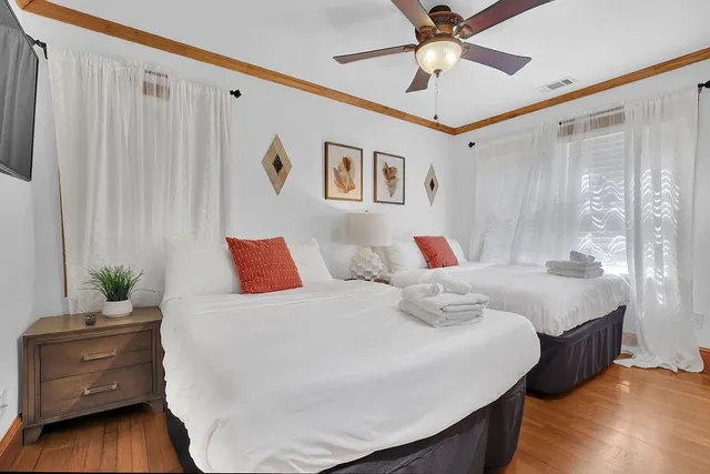 a bedroom with a large bed and a large window with wooden floor