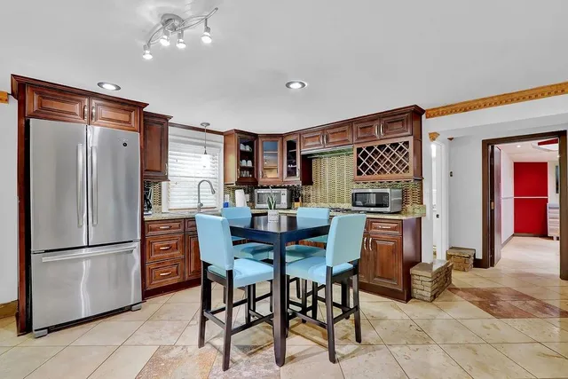a kitchen with stainless steel appliances granite countertop a refrigerator and a sink