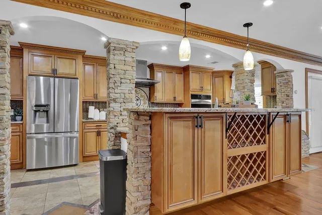 a kitchen with stainless steel appliances granite countertop a refrigerator and a sink