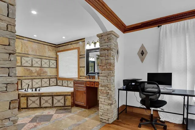 a view of a workspace with furniture and a window