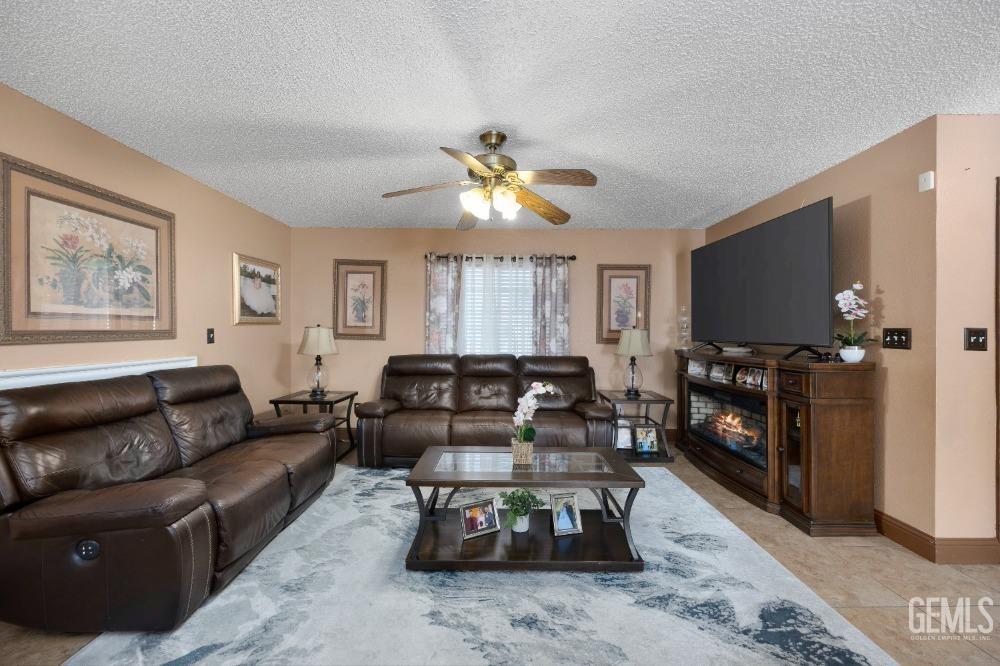 Undisclosed Address Shafter, CA 93263 - Photo 12 of 42 a living room with furniture a flat screen tv and a fireplace