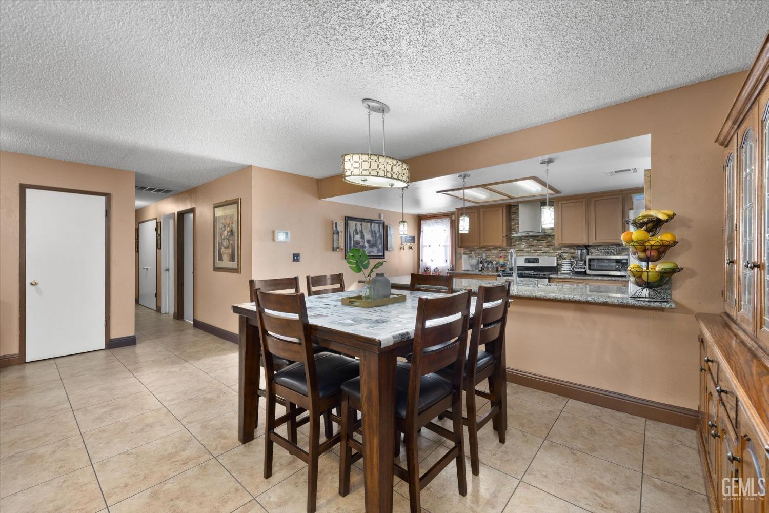 Undisclosed Address Shafter, CA 93263 - Photo 16 of 42 a kitchen with stainless steel appliances a dining table chairs and stove