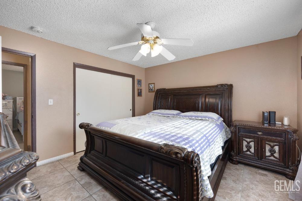 Undisclosed Address Shafter, CA 93263 - Photo 23 of 42 a bedroom with a bed and a chandelier