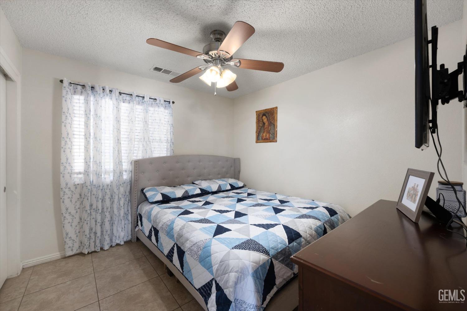 Undisclosed Address Shafter, CA 93263 - Photo 25 of 42 a bedroom with a bed and a chandelier