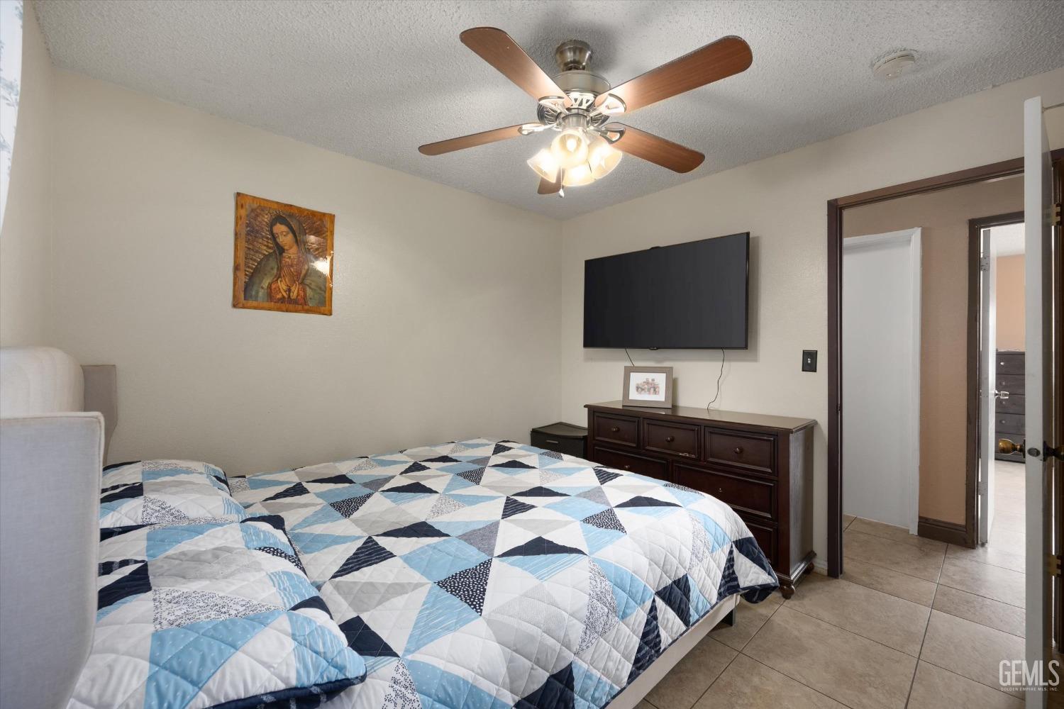 Undisclosed Address Shafter, CA 93263 - Photo 26 of 42 a bedroom with a large bed and a flat tv screen