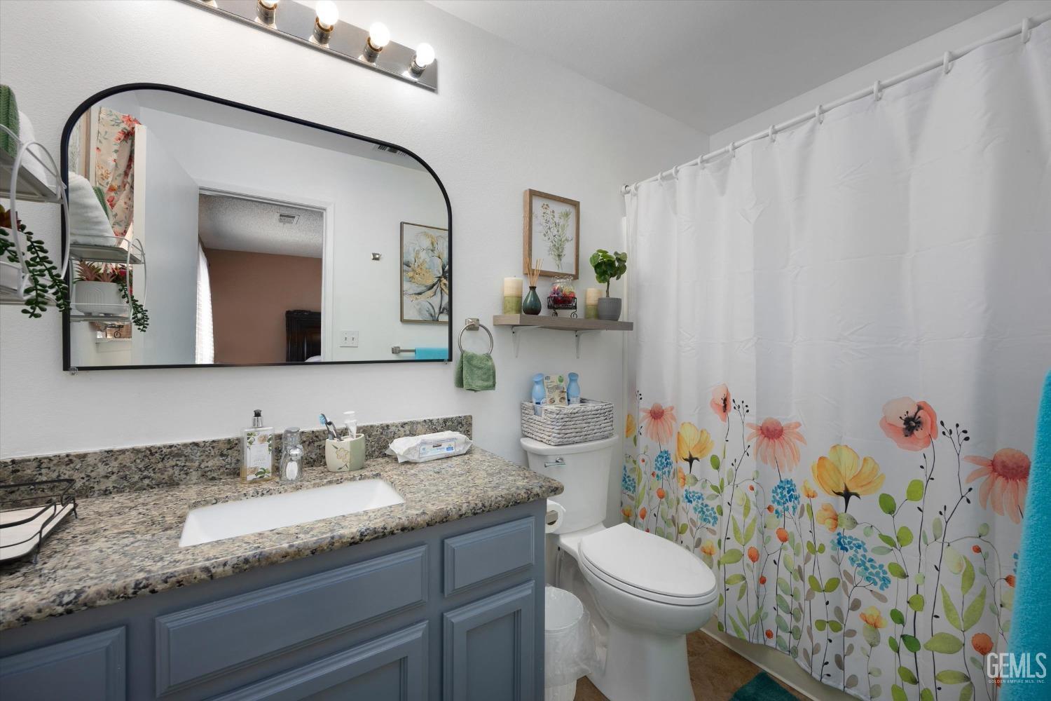 Undisclosed Address Shafter, CA 93263 - Photo 27 of 42 a bathroom with a granite countertop toilet sink and mirror