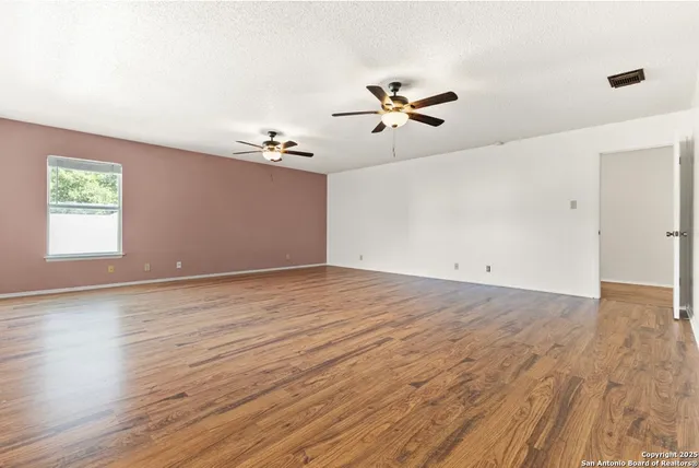 a view of room with hardwood floor and ceiling fan