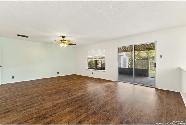 a view of a livingroom with wooden floor and a ceiling fan