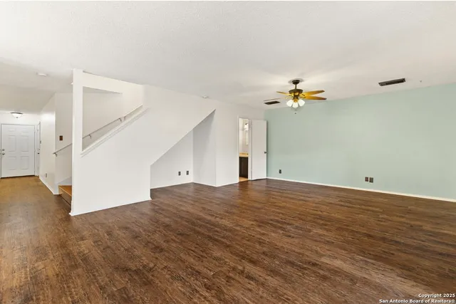 a view of a room with wooden floor and white walls