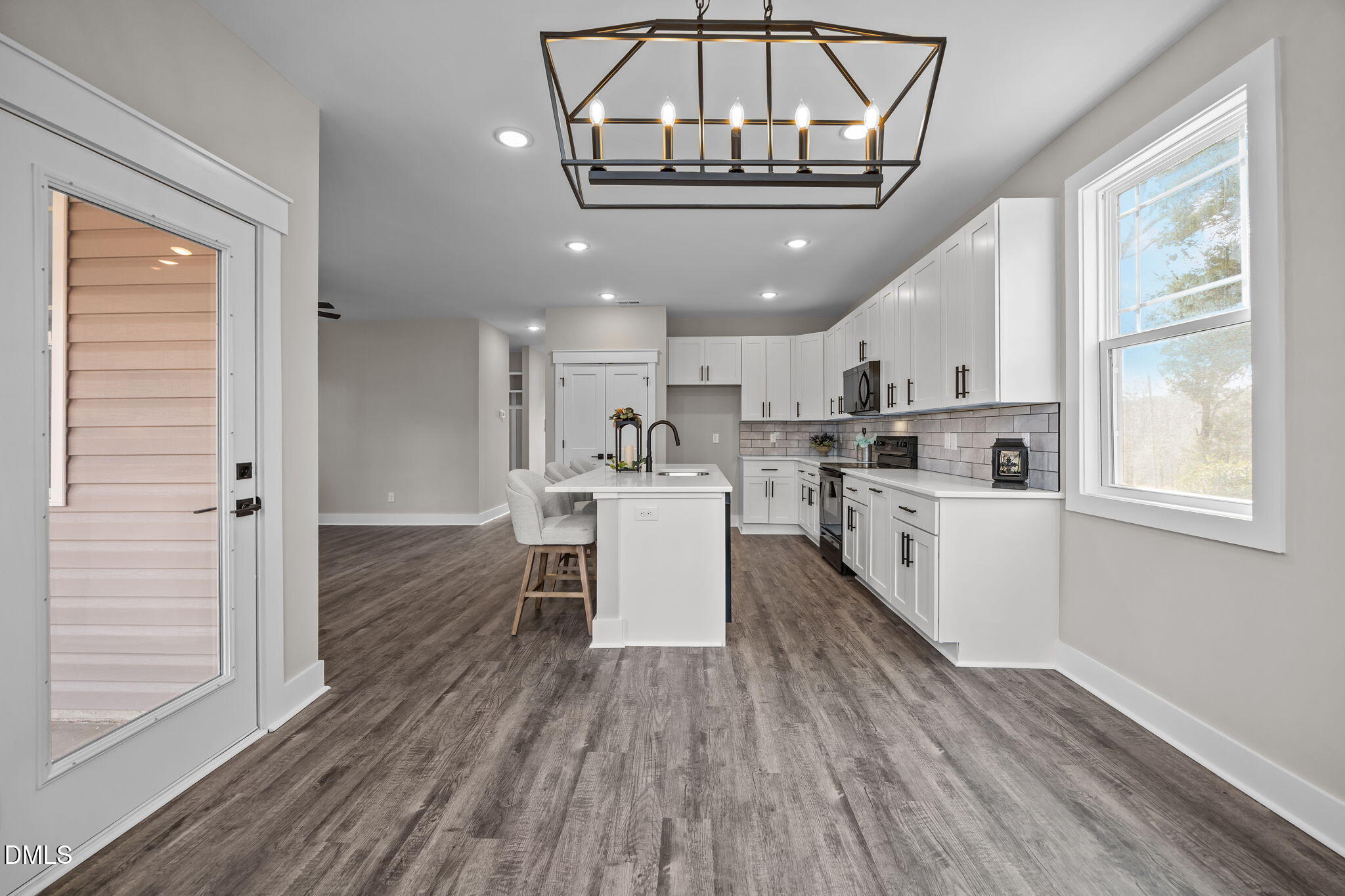 3917 Highway 42 Raleigh, NC 27603 - Photo 9 of 46 a kitchen with a chandelier stainless steel appliances refrigerator sink and cabinets