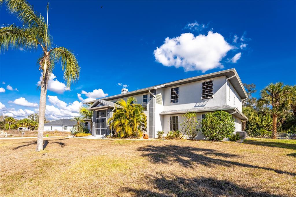 196 Lecturn Street Port Charlotte, FL 33954 - Photo 60 of 72 a front view of a house with a yard