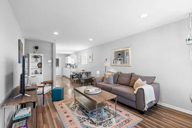 a living room with furniture a rug and a table