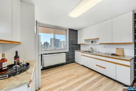 a kitchen with a sink wooden floor and white appliances