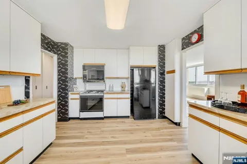 a kitchen with a refrigerator and a stove top oven