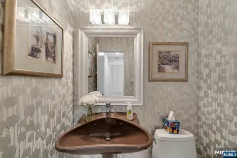 a bathroom with a toilet a sink and mirror