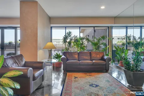 a living room with furniture potted plant and a large window