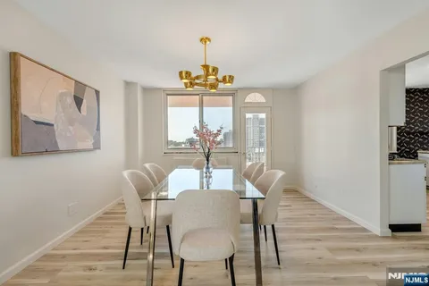 a dining room with furniture a chandelier and wooden floor
