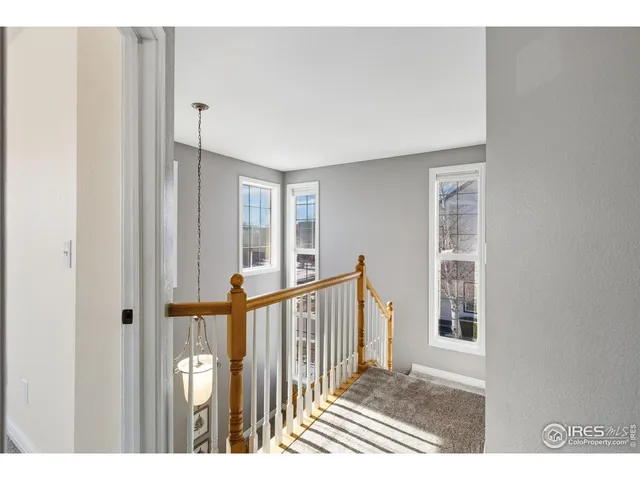 a view of a bedroom with wooden floor & windows