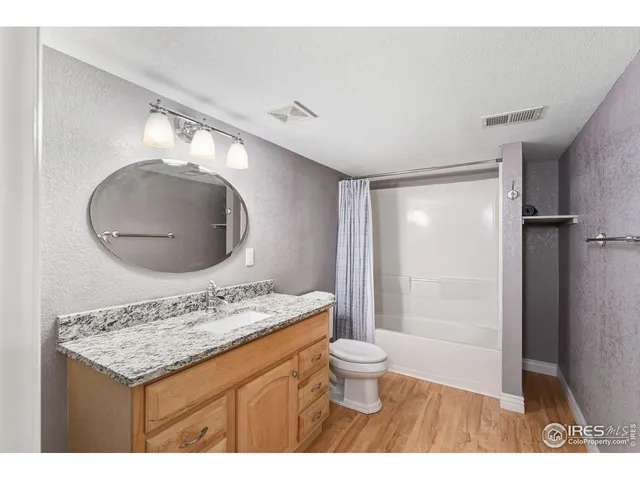 a bathroom with a granite countertop sink a mirror and a shower