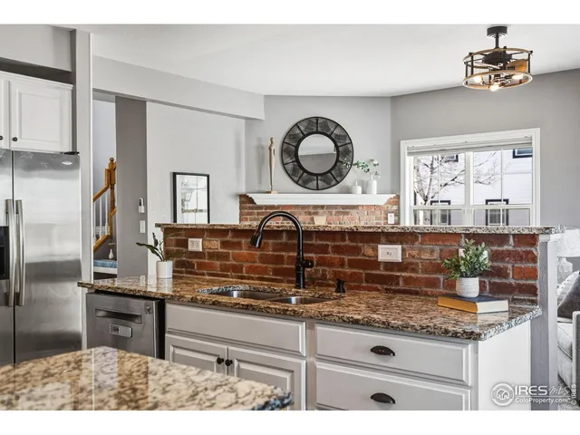 a kitchen with kitchen island granite countertop a stove a sink and a refrigerator