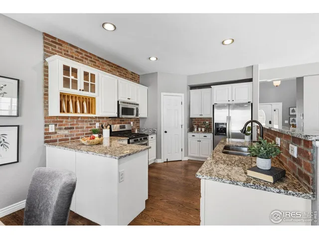 a kitchen with stainless steel appliances granite countertop a stove top oven a sink refrigerator and cabinets