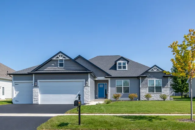 a front view of a house with a garden and yard
