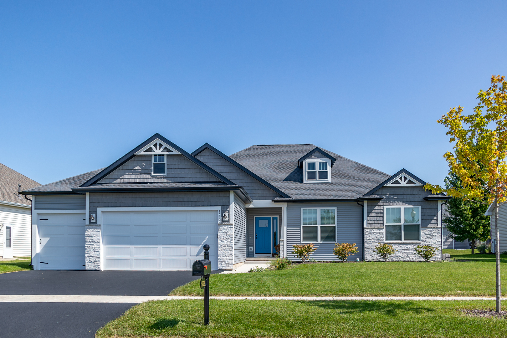 a front view of a house with a garden and yard