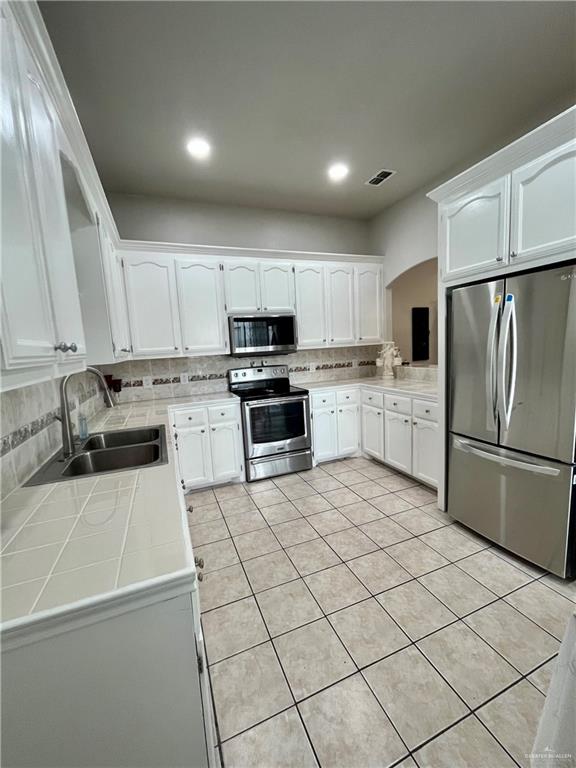 2113 South 3rd Street McAllen, TX 78503 - Photo 20 of 26 a kitchen with granite countertop a refrigerator sink and white cabinets