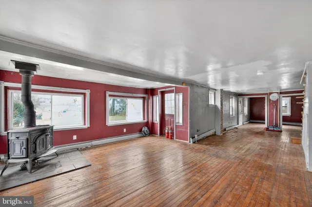 a view of large hall with wooden floor and windows