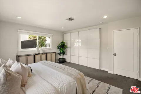 a bedroom with a large bed and a large window
