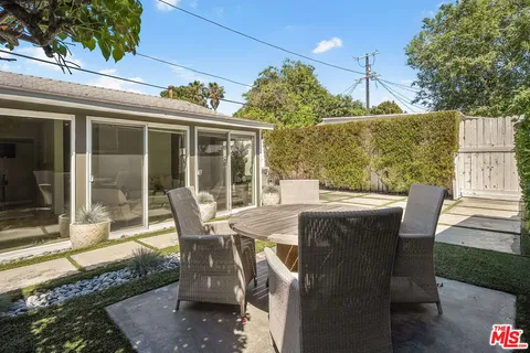 a view of an outdoor dining space with a table and chairs