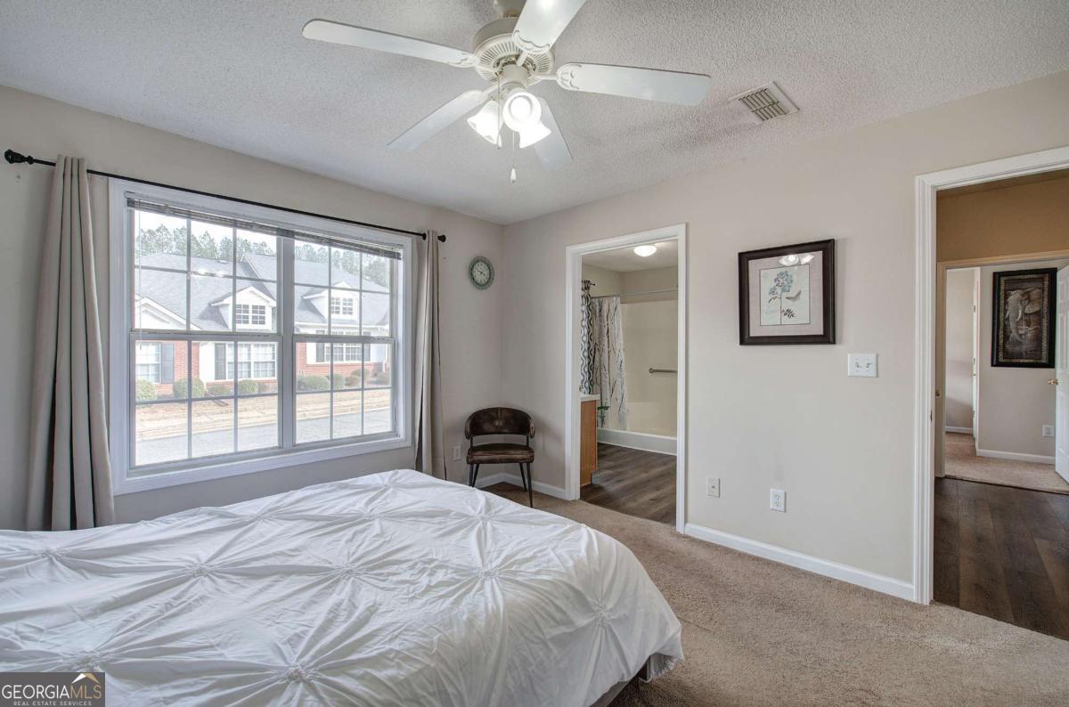 150 Old Mill Road, Unit 123 Cartersville, GA 30120 - Photo 13 of 27 a bedroom with a large bed and a chandelier