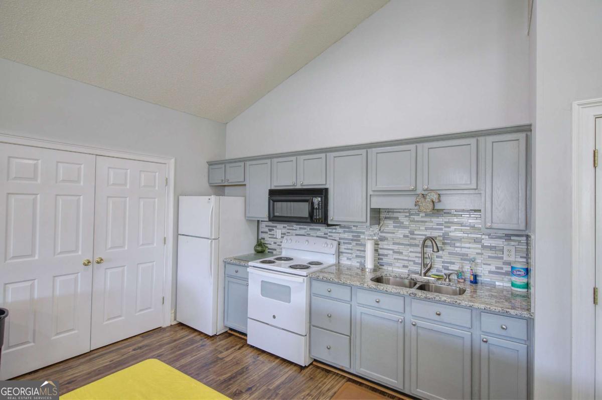 150 Old Mill Road, Unit 123 Cartersville, GA 30120 - Photo 27 of 27 a kitchen with granite countertop white cabinets and stainless steel appliances