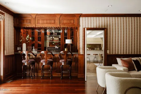 a living room with furniture a fireplace and a floor to ceiling window