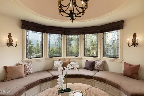 a bedroom with a bed a desk and chair with the large mirror