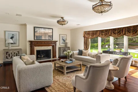 a living room with furniture a fireplace and a large window