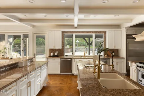 a large kitchen with kitchen island a large counter space appliances and furniture