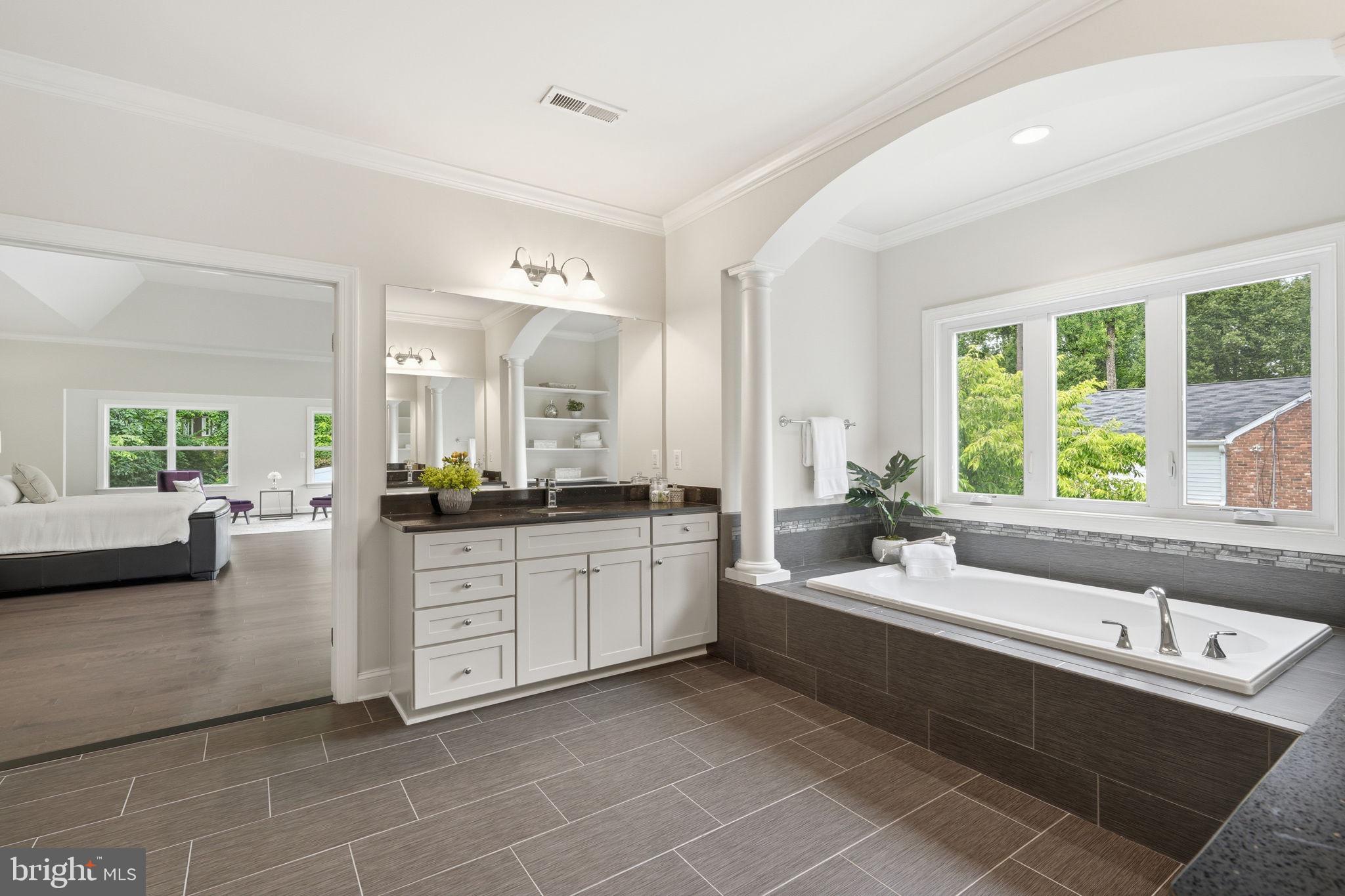 7821 Old Falls Road McLean, VA 22102 - Photo 29 of 62 a large white bathroom with a large tub sink and mirror