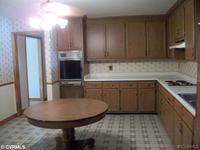 6328 Commander Road Richmond, VA 23224 - Photo 5 of 12 a kitchen with stainless steel appliances granite countertop a sink a stove a microwave a counter top and cabinets