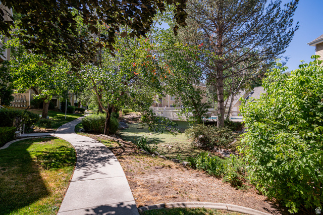 1221 Waterside Cove, Unit 11 Midvale, UT 84047 - Photo 22 of 23 Winding concrete pathway with mature trees and established landscaping