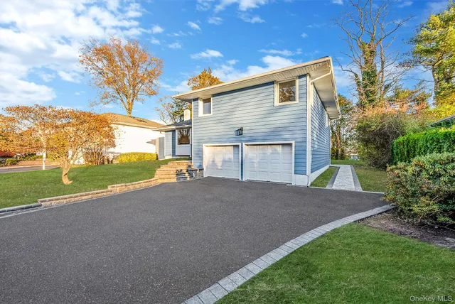 a view of a house with a yard and large tree