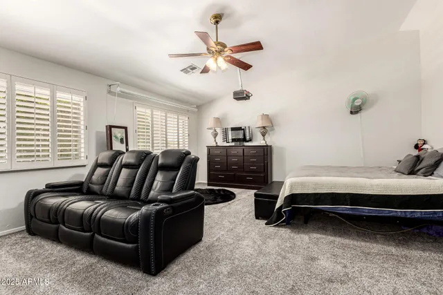 a living room with furniture ceiling fan and a window