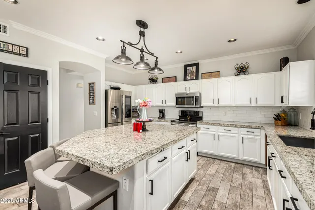 a kitchen with stainless steel appliances granite countertop a sink stove and refrigerator