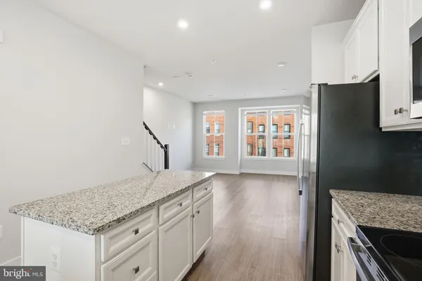 a kitchen with granite countertop a oven a cabinets and wooden floor