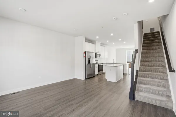 a view of kitchen with wooden floor and electronic appliances