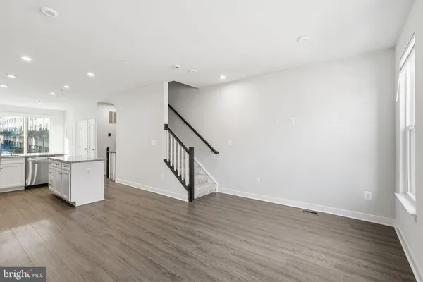 a view of a kitchen with wooden floor and electronic appliances
