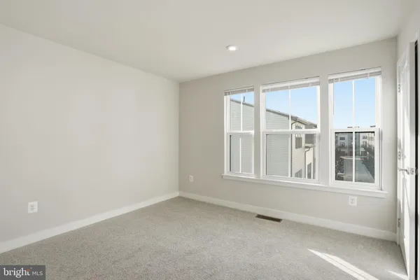 an empty room with a bathroom and a hallway